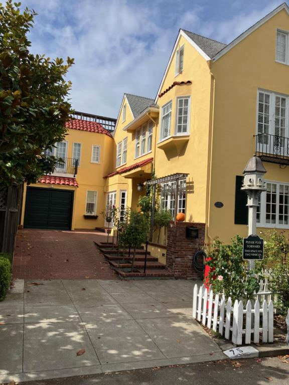 旧金山我的玫瑰园客房住宿加早餐旅馆的一排带白色围栏的黄色房屋