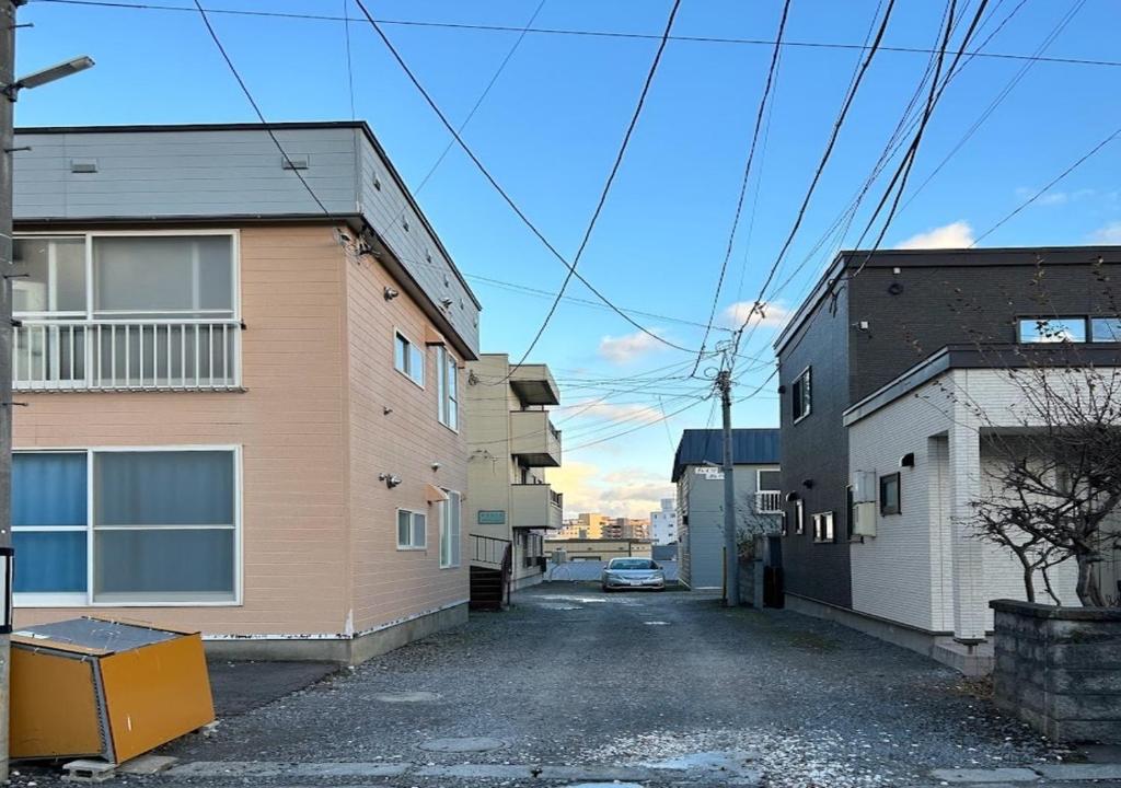 小樽Ota Apartment - Vacation STAY 16060的两栋建筑之间的小巷,旁边停有一辆汽车