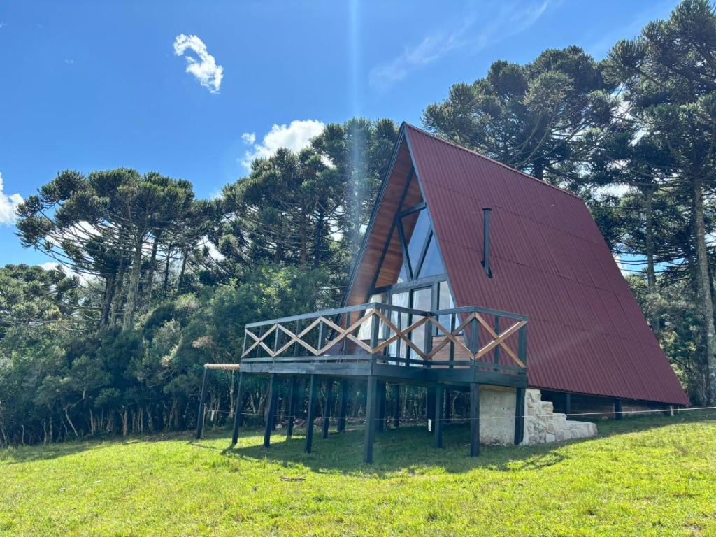 坎巴拉Chalés Corucacas的绿色田野上一座红色屋顶的房子