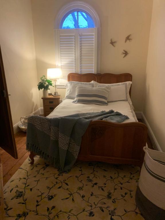 伯明翰Albany house的卧室内的一张床位,卧室配有窗户和床边镜