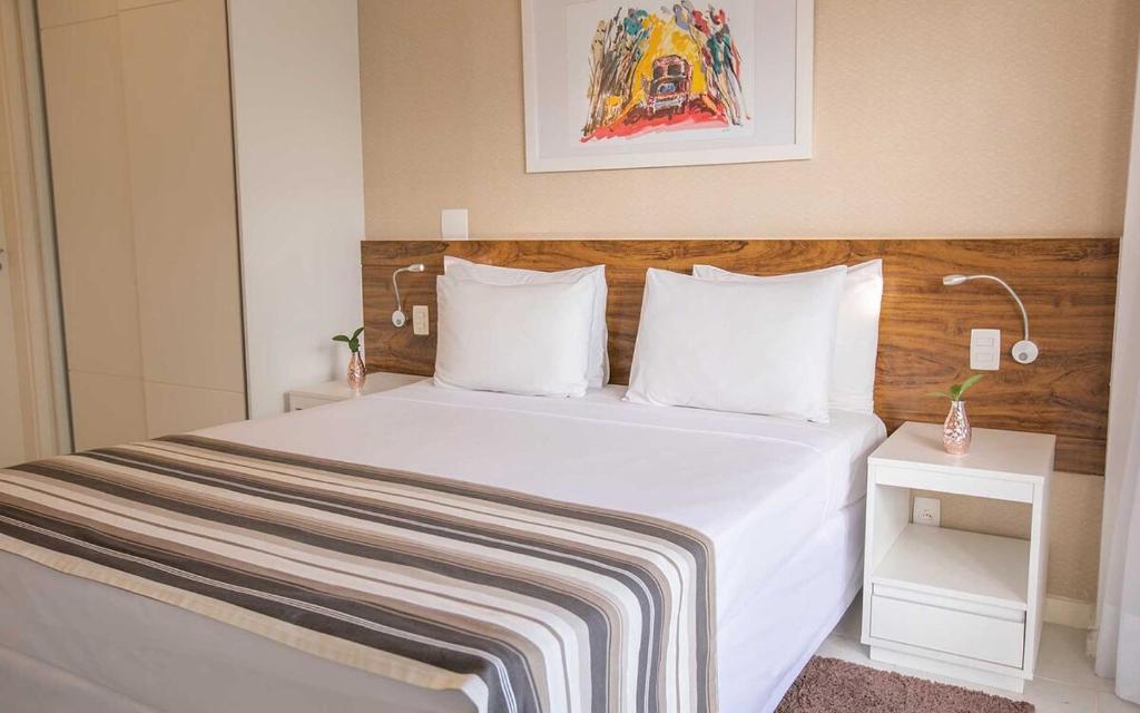 巴西利亚Vision Diária Brasil 06908的卧室配有一张带白色床单和枕头的大床。
