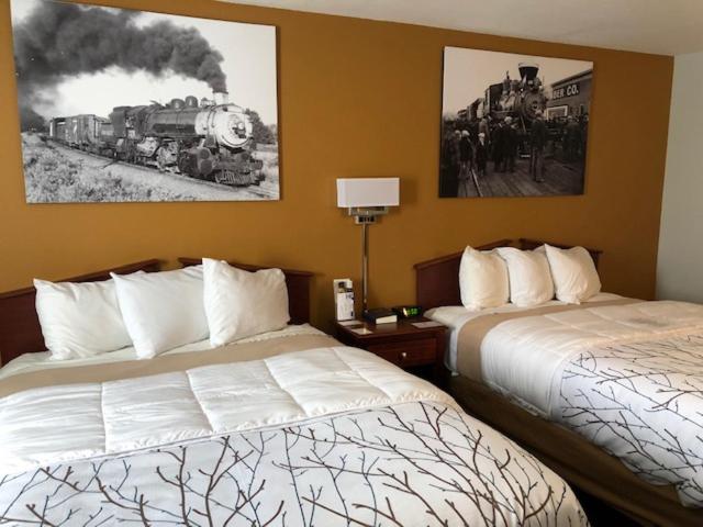 MarysvilleHeritage Inn Express的酒店客房设有两张床,墙上挂有火车画