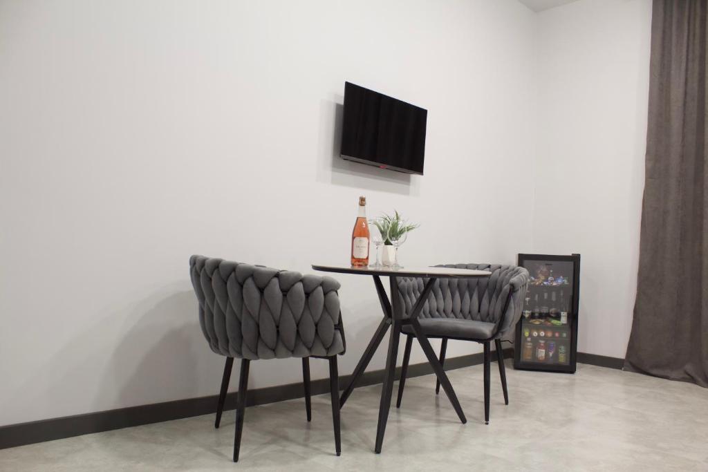 PʼarakʼarLux Plaza (New Rooms)的餐桌、两把椅子和一瓶葡萄酒