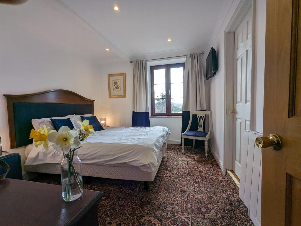 Saint-Amand-JartoudeixTrente-Trois Le Nouhaud的一间卧室,配有一张床,桌子上放着花瓶