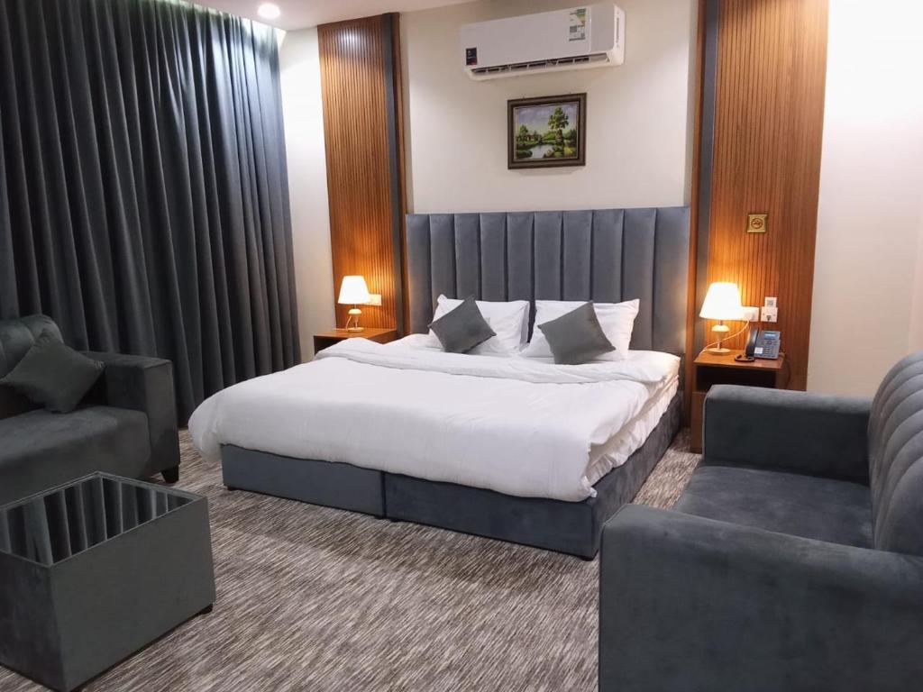 麦地那فندق انسام طيبة للضيافة的酒店客房配有一张床、一把椅子和一张沙发