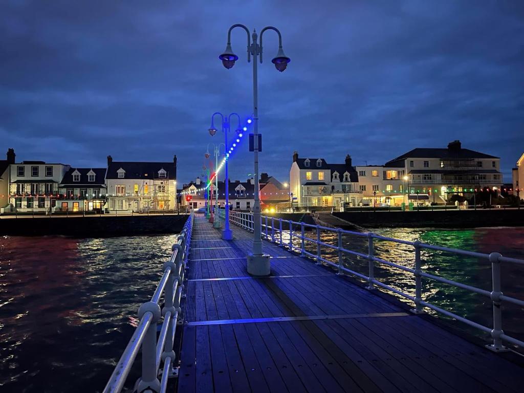 圣赫利尔泽西得勒唐旅馆的夜间水面上灯的码头