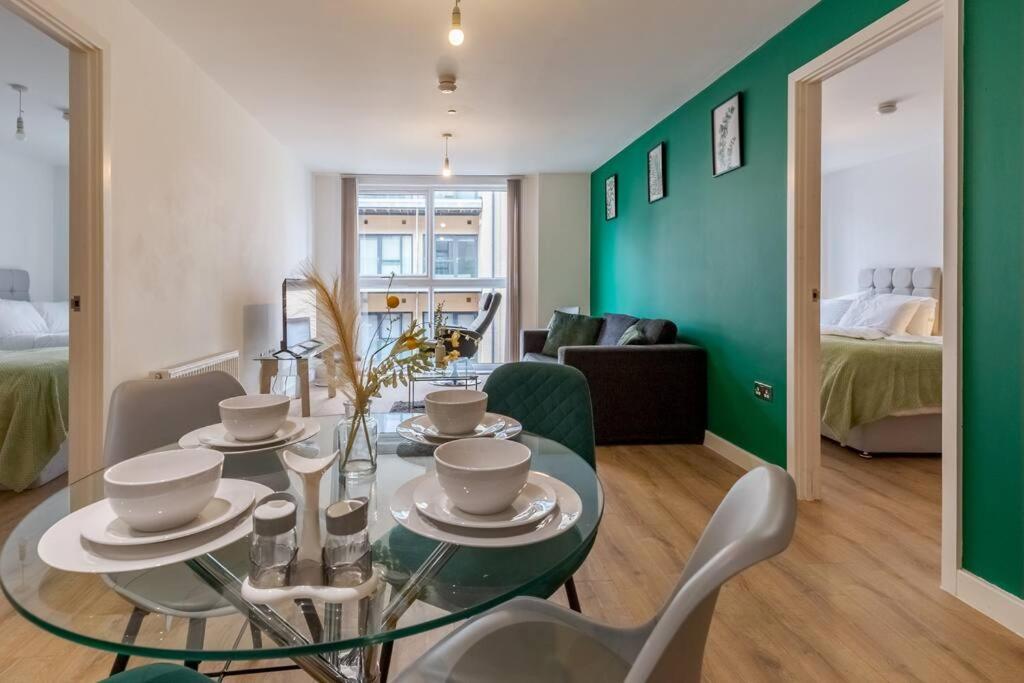 伯明翰Comfy • Quiet • Your Other Home的一间设有玻璃桌和绿色墙壁的用餐室