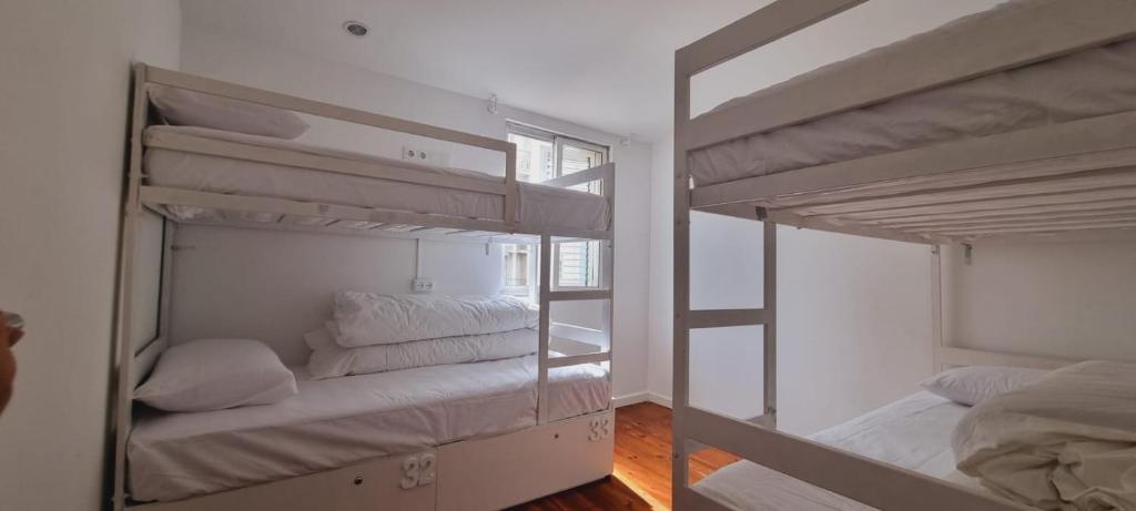 波尔图Owls Hostel Ribeiro的带窗户的客房内的两张双层床