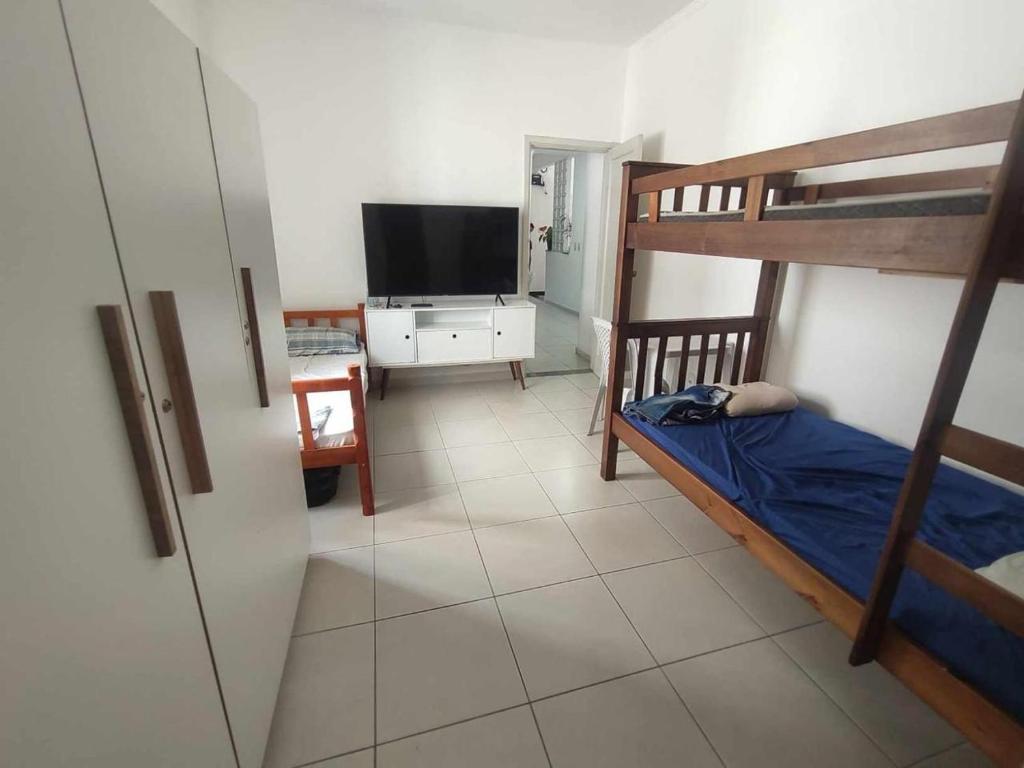 桑托斯Residência RCA13的一间卧室配有双层床和电视。