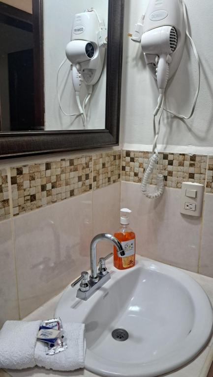 特拉Maho's Apartamentos的浴室水槽、吹风机和镜子