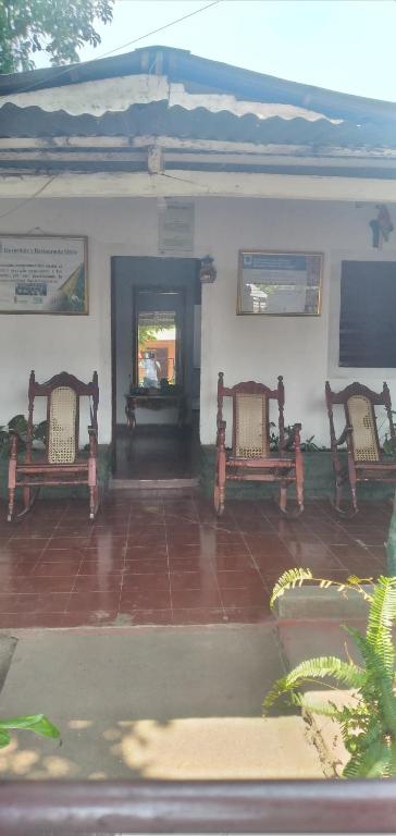 AltagraciaOrtiz Hospedaje Ometepe的两个长椅坐在大楼前