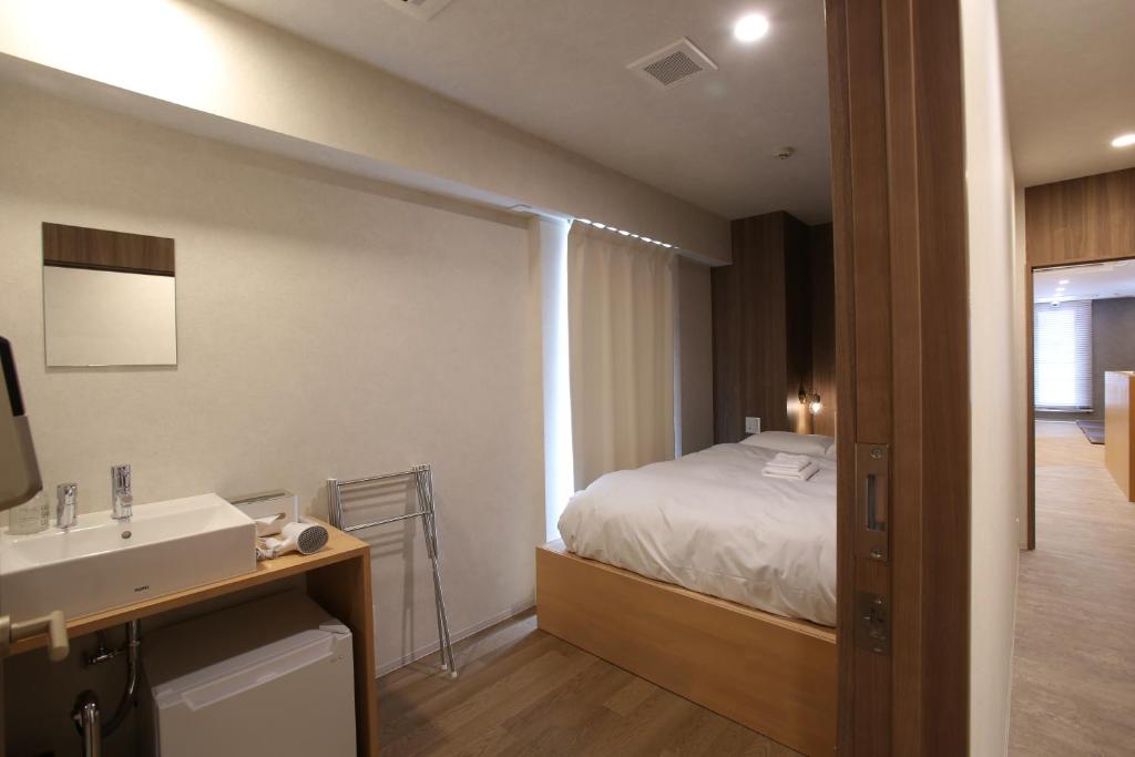东京OHWA hostel minowa station的客房内的浴室设有床和水槽