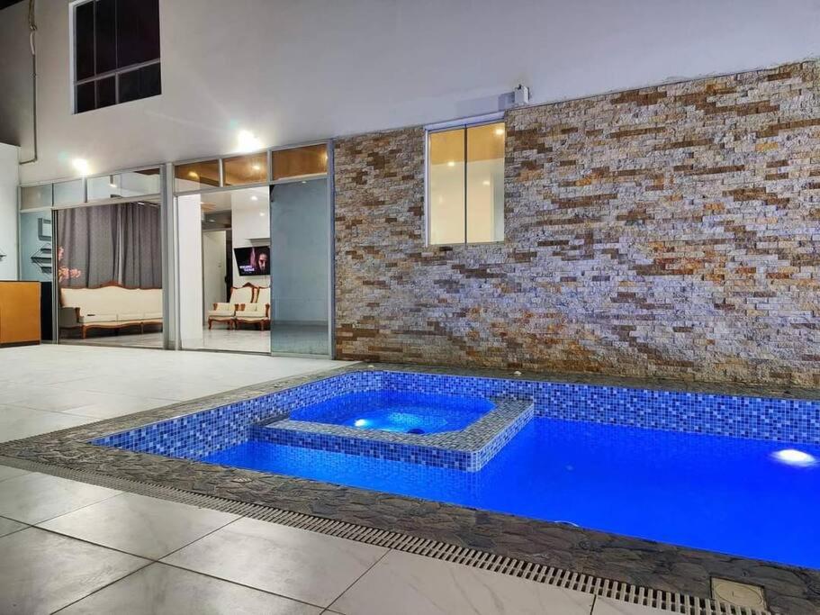 伊察Casa Privada de Estreno con Piscina en Ica的一座大型蓝色游泳池,位于一间砖墙房间内