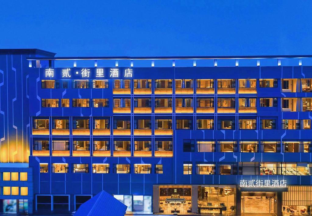 简阳南贰·街里酒店(成都天府国际机场店)的蓝色的建筑,灯火通明