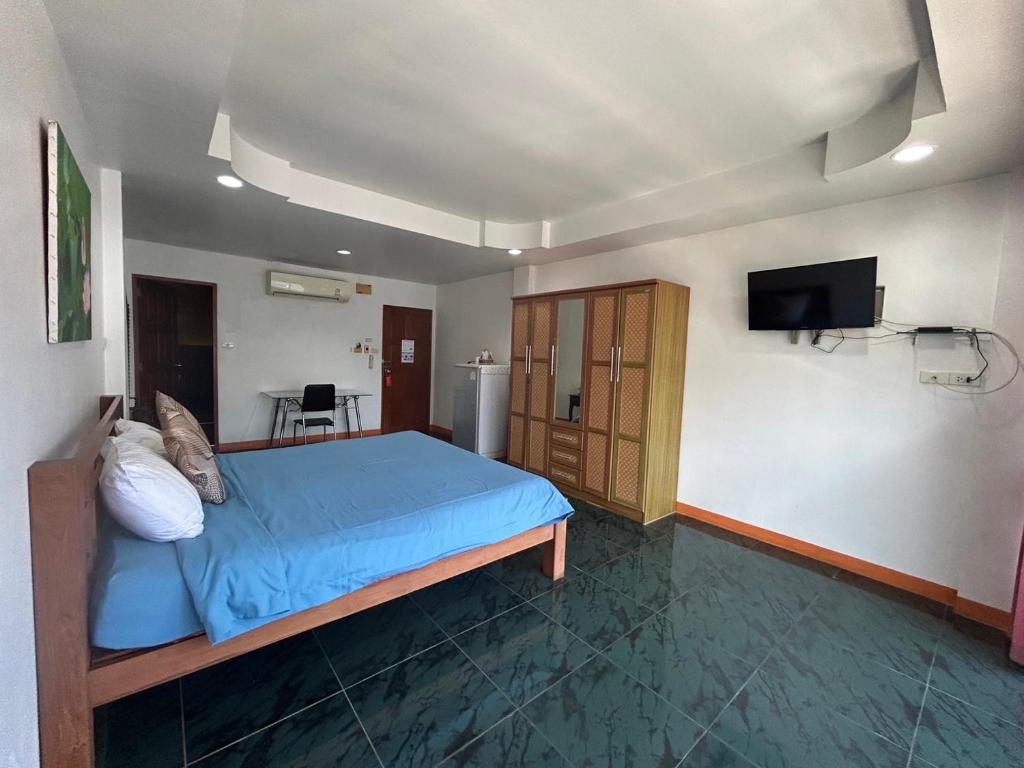 南芭堤雅Coffeeandbeer的一间卧室配有蓝色的床和一台平面电视