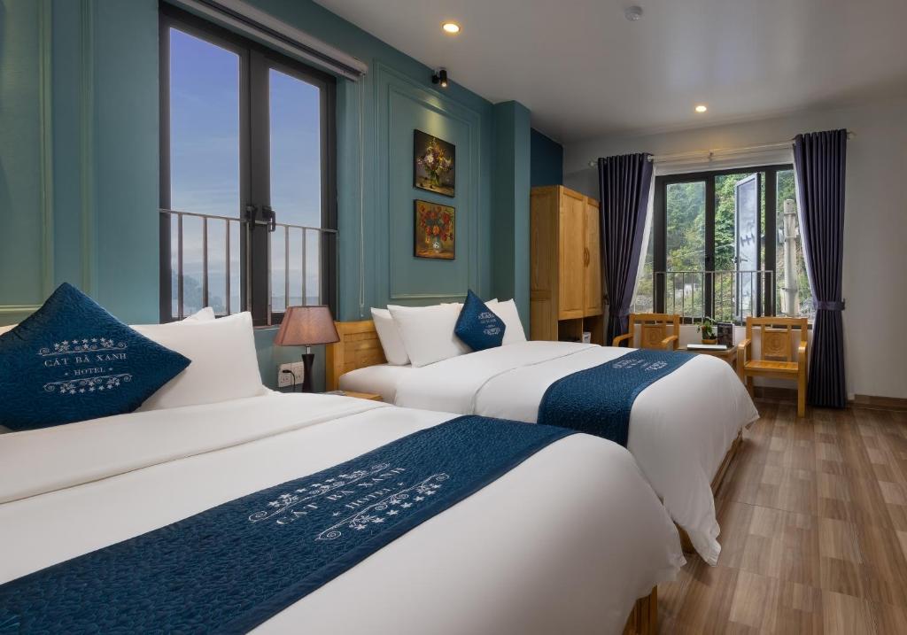 吉婆岛Cat Ba Xanh Spring Garden Hotel的配有两张床铺的蓝色墙壁和窗户
