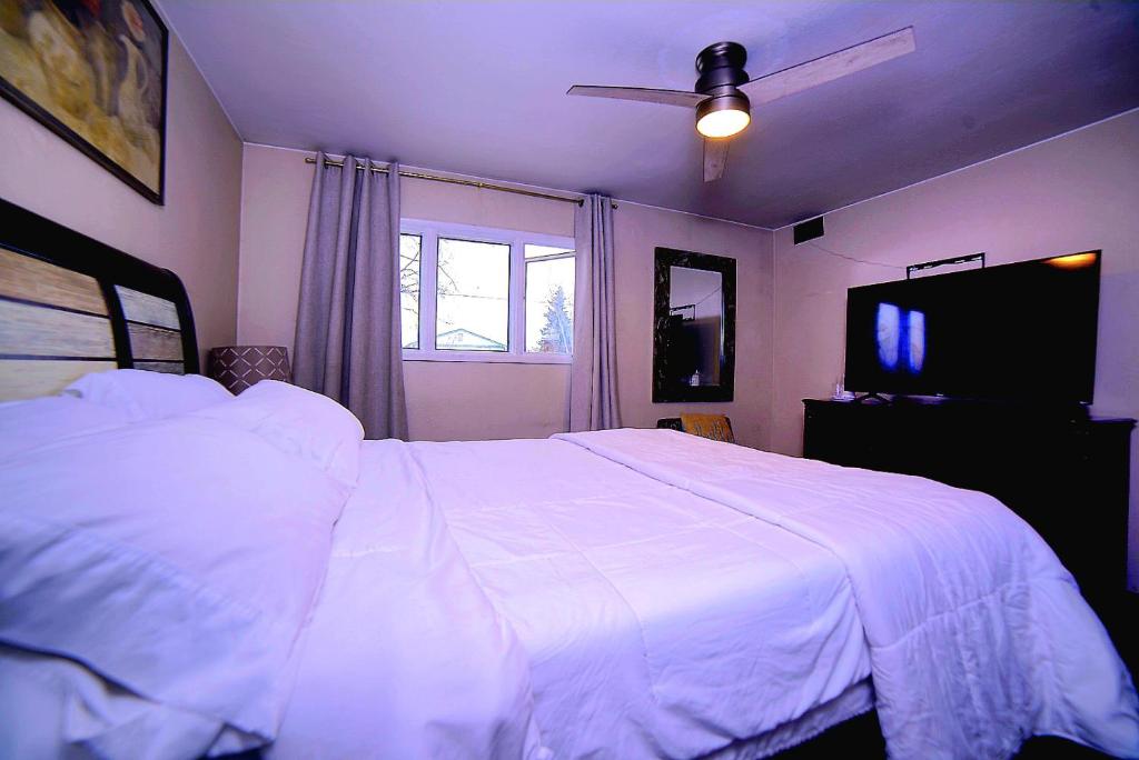 安克雷奇KING SUITE ON 16TH AVE的卧室配有白色的床和电视