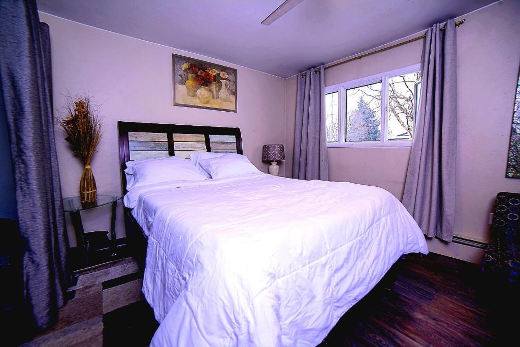 安克雷奇KING SUITE ON 16TH AVE的卧室配有一张带白色床单的大床和窗户。