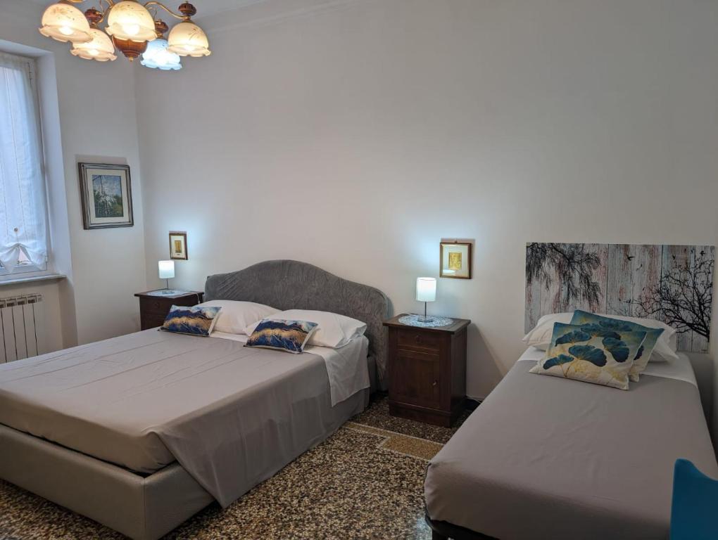 热那亚CasaLeonardo的一间卧室配有两张床和吊灯。