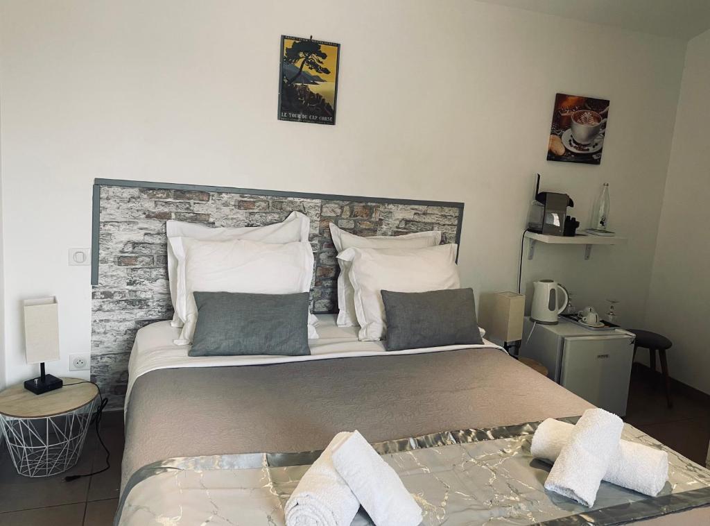 科尔特Hôtel U Passa Tempu的一间卧室设有一张带砖墙的大床