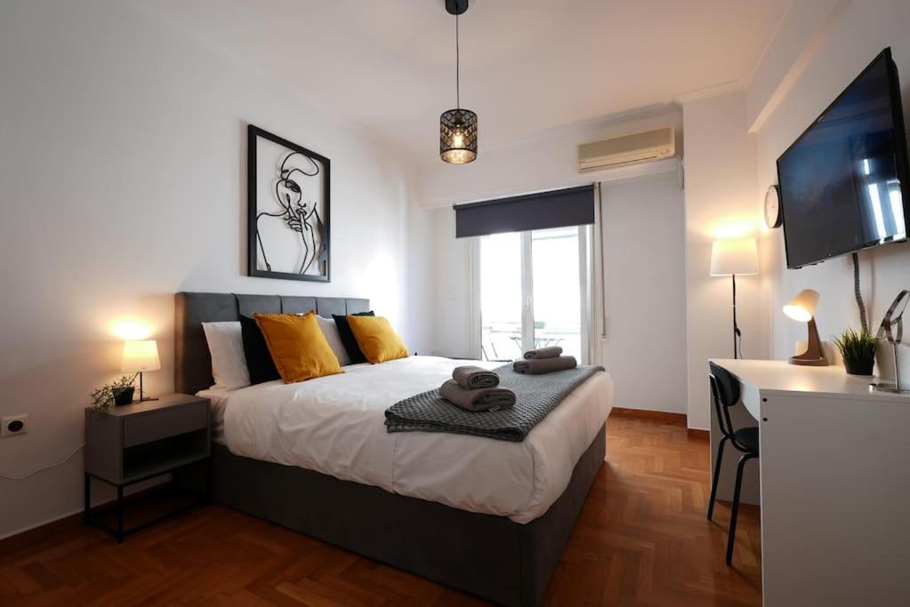 雅典Syntagma square, 70sqm Pentelis sunny apartment的一间卧室配有一张床、一张书桌和一台电视