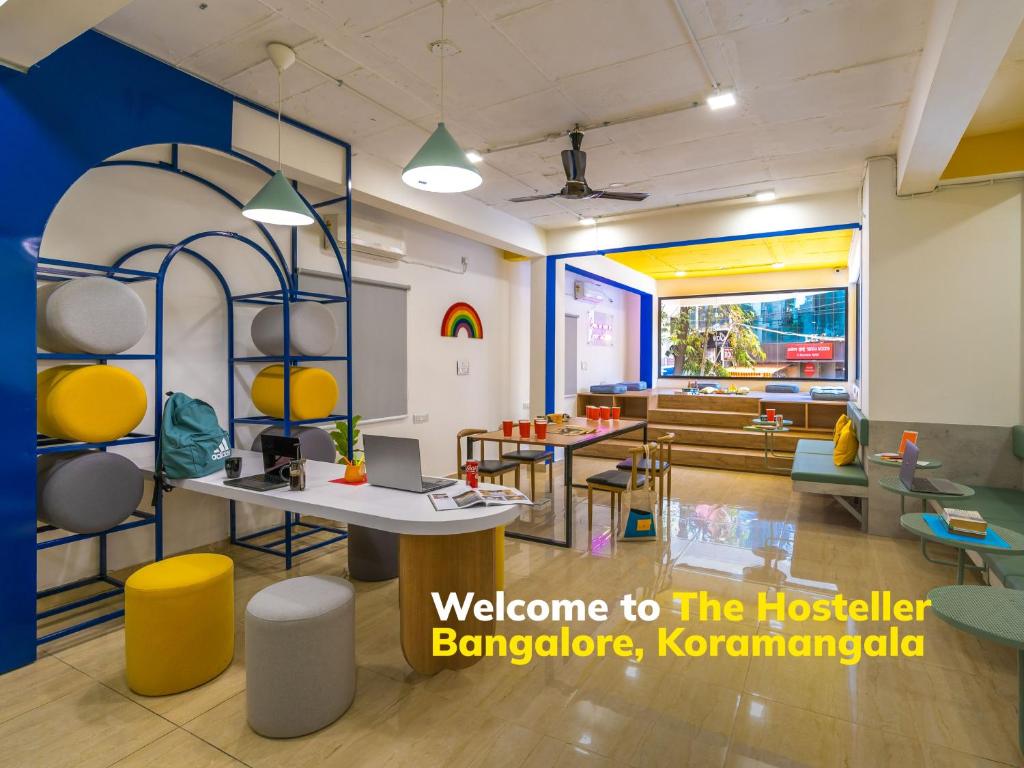 班加罗尔The Hosteller Bangalore, Koramangala的配有桌椅和沙发的房间