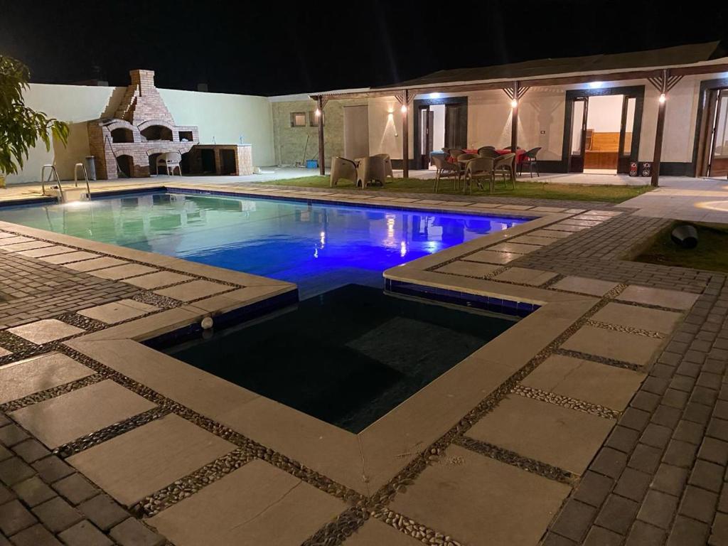 Qaryat ash Shamālīشاليه للايجار اليومي بالريف الاوروبي的夜间在院子里的游泳池