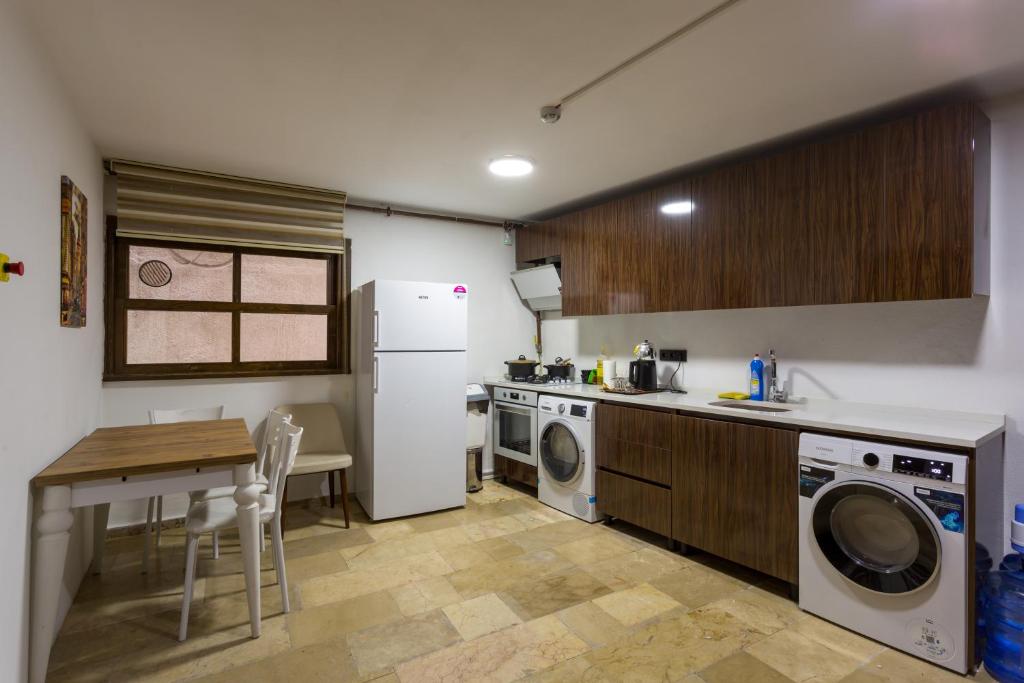 伊斯坦布尔Dream Park Hotel的厨房配有洗衣机、烘干机和桌子