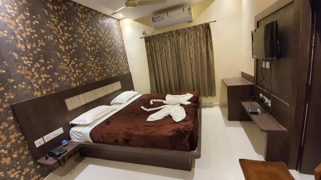 普里Hotel Home Town Puri - Lift - Parking - Near Golden Beach - Excellent Service Recommended的一间酒店客房,配有一张带毛巾的床