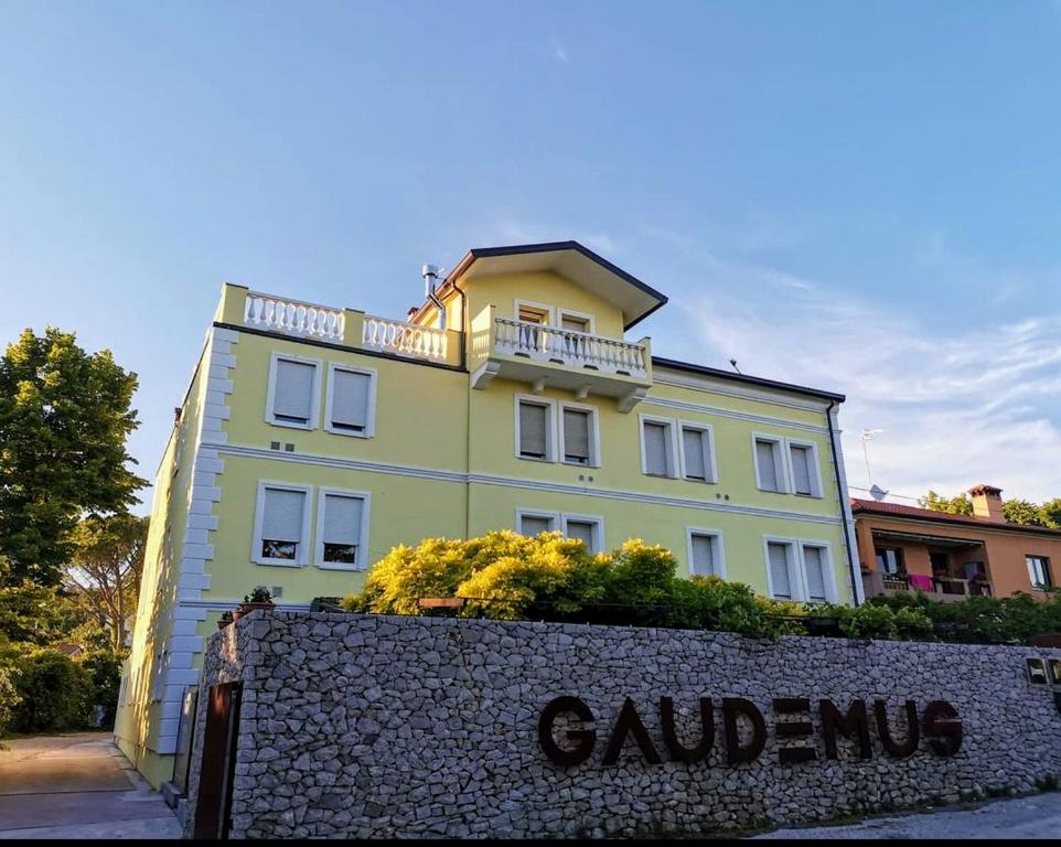 西斯蒂亚纳Locanda Gaudemus Boutique Hotel的黄色的建筑,上面设有阳台