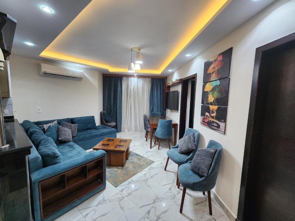 塞得港Porto said بورتوسعيد غرفتين وصاله的客厅配有蓝色的沙发和椅子