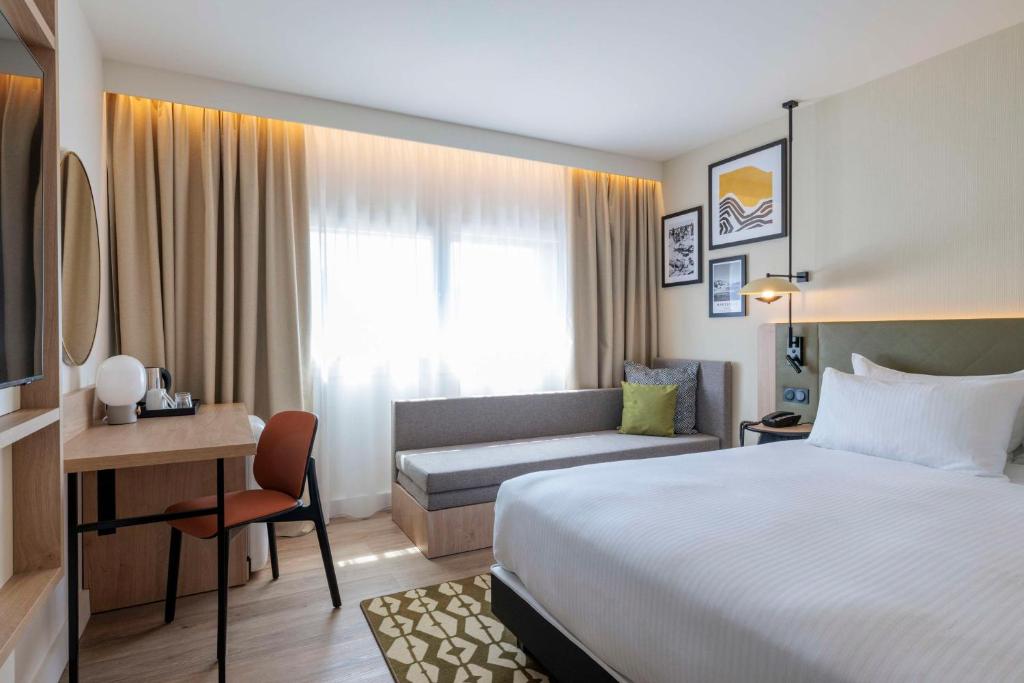 马里尼亚讷Hilton Garden Inn Marseille Provence Airport的配有一张床和一张书桌的酒店客房