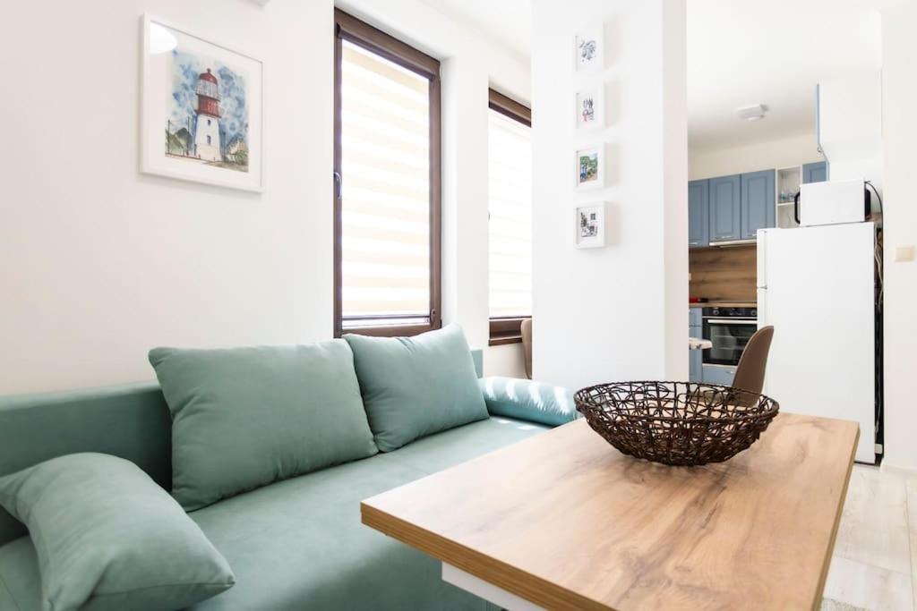 布尔加斯Summer Vibes Apartment的客厅配有绿色沙发和木桌