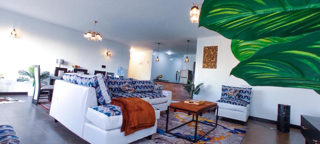 内罗毕Top Tier Home的客厅配有白色家具和绿色植物
