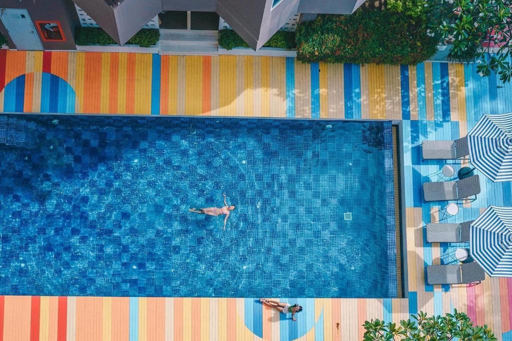 华欣Sila at Hua Hin Serviced Apartment & Hotel的一个人在游泳池游泳,而一个人在游泳池里游泳