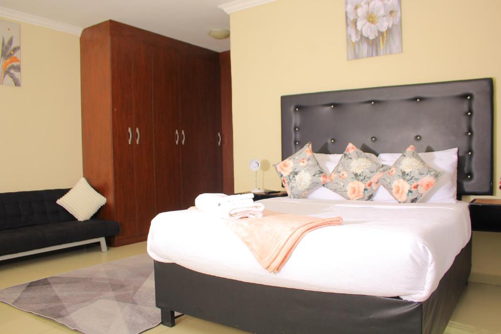 哈博罗内Kunzi B&B的一间卧室配有一张大床和黑色床头板
