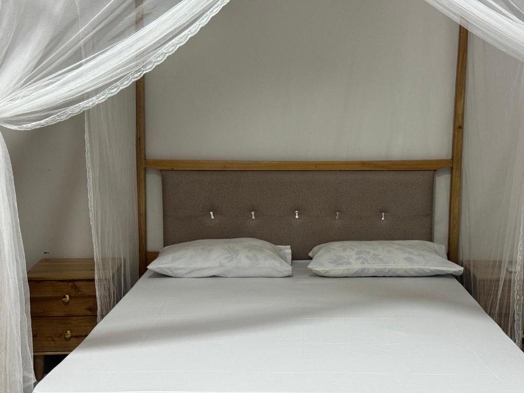 莫罗戈罗Winnie's Home的卧室内的一张带两个枕头的床