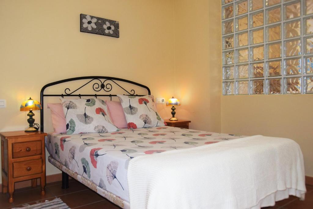 拉特吉塔Alquilaencanarias-La Tejita Pirata!的一间卧室配有一张床、两盏灯和一个窗户。