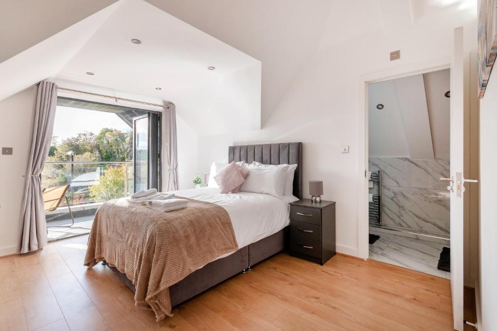 寇斯顿Refined Living: Three Bedrooms Flat in Coulsdon CR5的白色的卧室设有床和大窗户