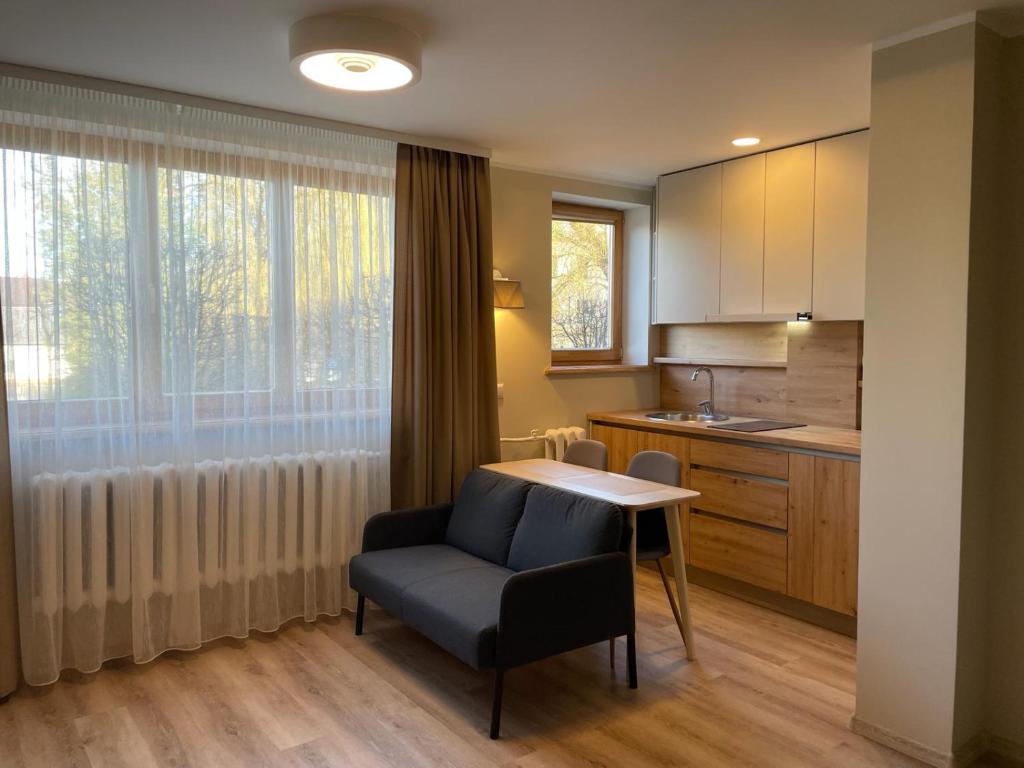 叶尔加瓦Centra dzīvoklis的厨房配有桌子、椅子和窗户