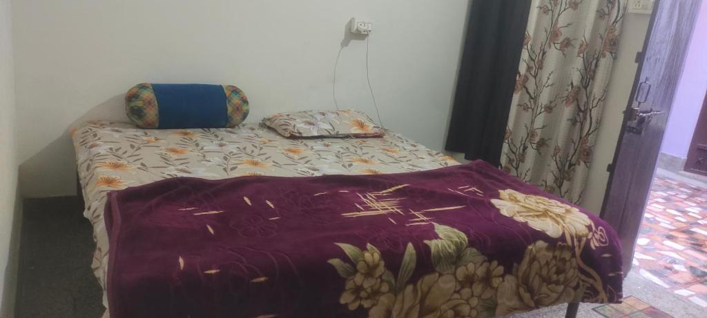 范兰德凡Shree Giriraj homestay的一张带紫色毯子和枕头的床