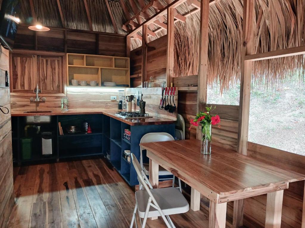 圣玛尔塔Casa Sol Y Sombra的厨房铺有木地板,配有木桌。