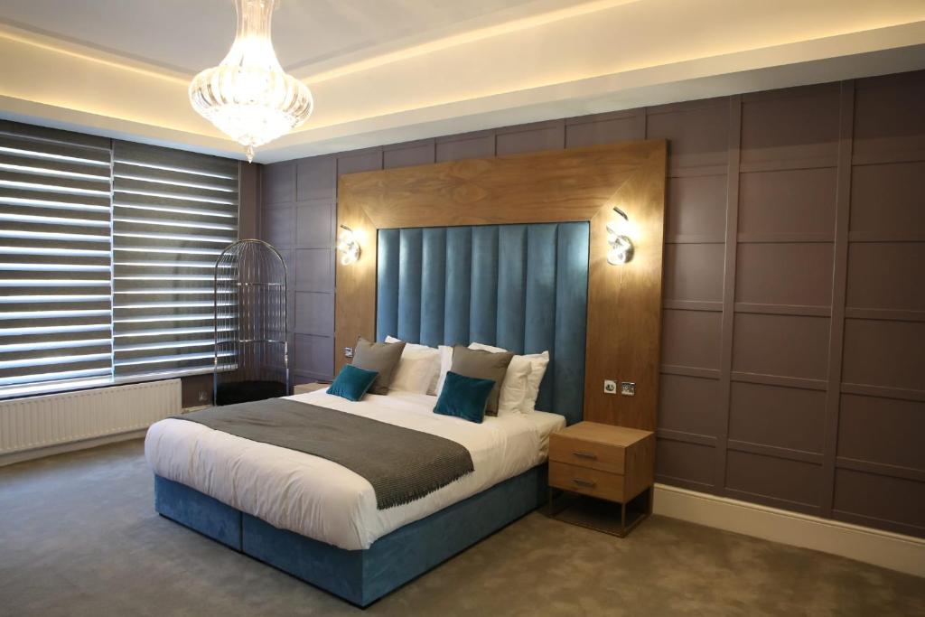 赫特福德Ponsbourne Park的一间卧室配有一张大床和一个吊灯。