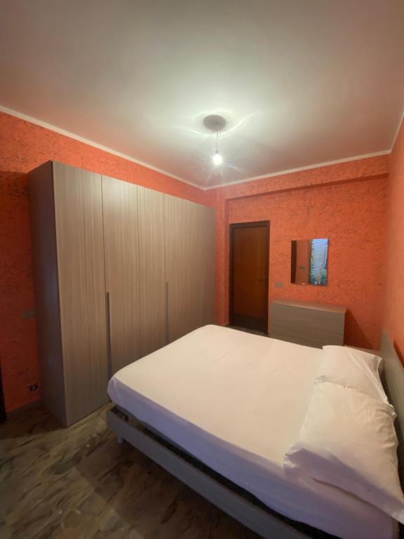 卡鲁尼亚玛丽娜La villetta的卧室配有白色的床和橙色的墙壁