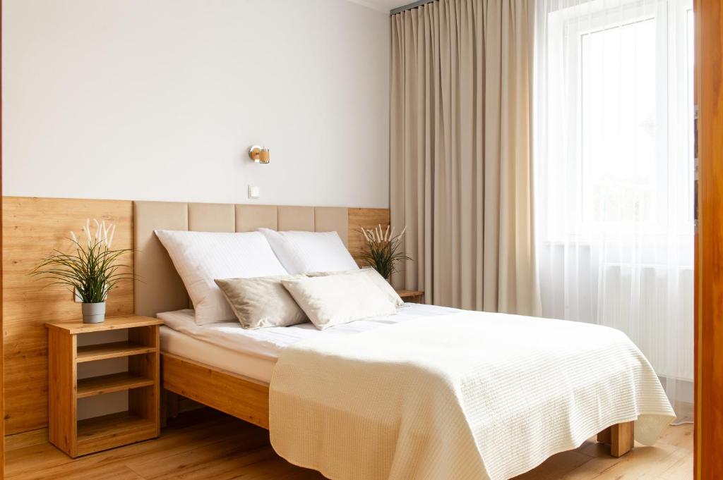 卡尔维亚Willa Karol的一间卧室配有一张带白色床单的床和一扇窗户。