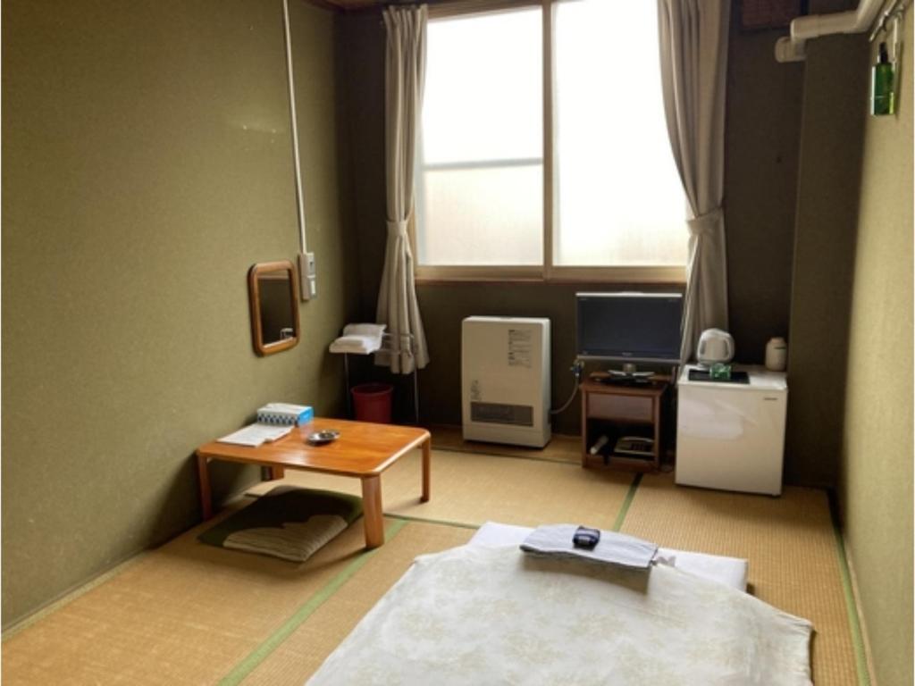 函馆Hotel Tetora Yunokawaonsen - Vacation STAY 30541v的客房设有桌子、书桌和窗户。