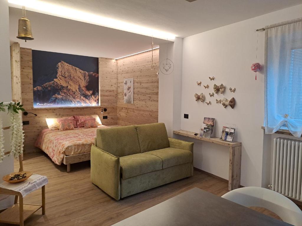 莱维科特尔梅Monolocale La Rosa的一间卧室配有一张床、一张沙发和一把椅子