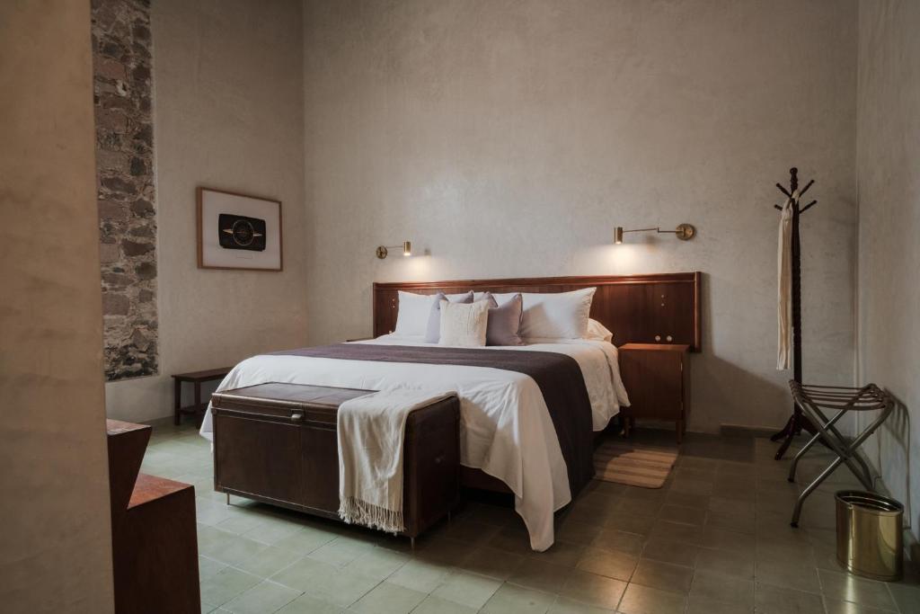 克雷塔罗Hotel Hércules的卧室配有一张带白色床单和枕头的大床。