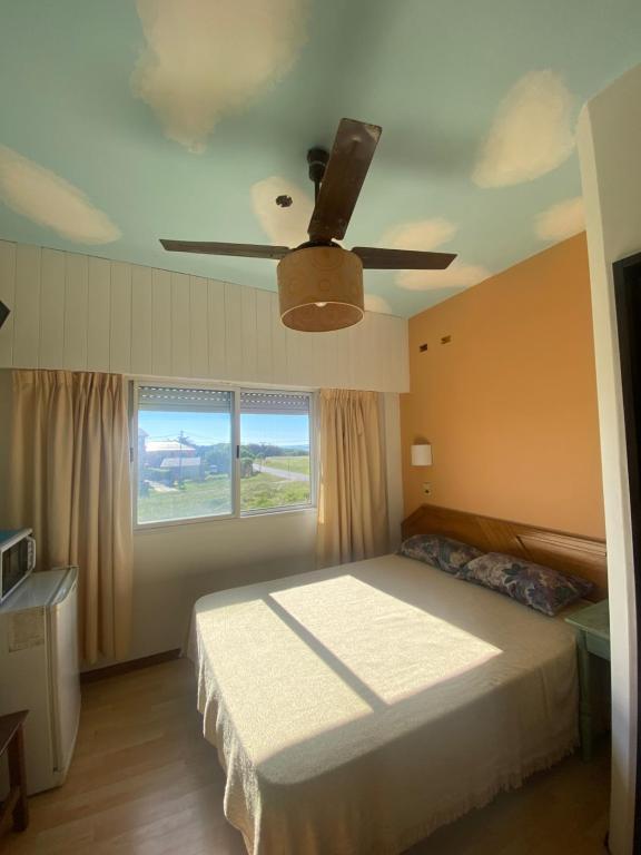 马德普拉塔Habitación frente al mar的一间卧室配有一张床和吊扇