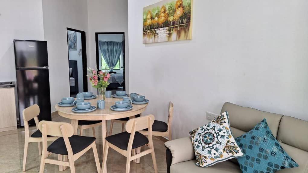 Kampung MawarOcean Cottage 2, Radiant Teluk Sari的客厅配有桌子和沙发